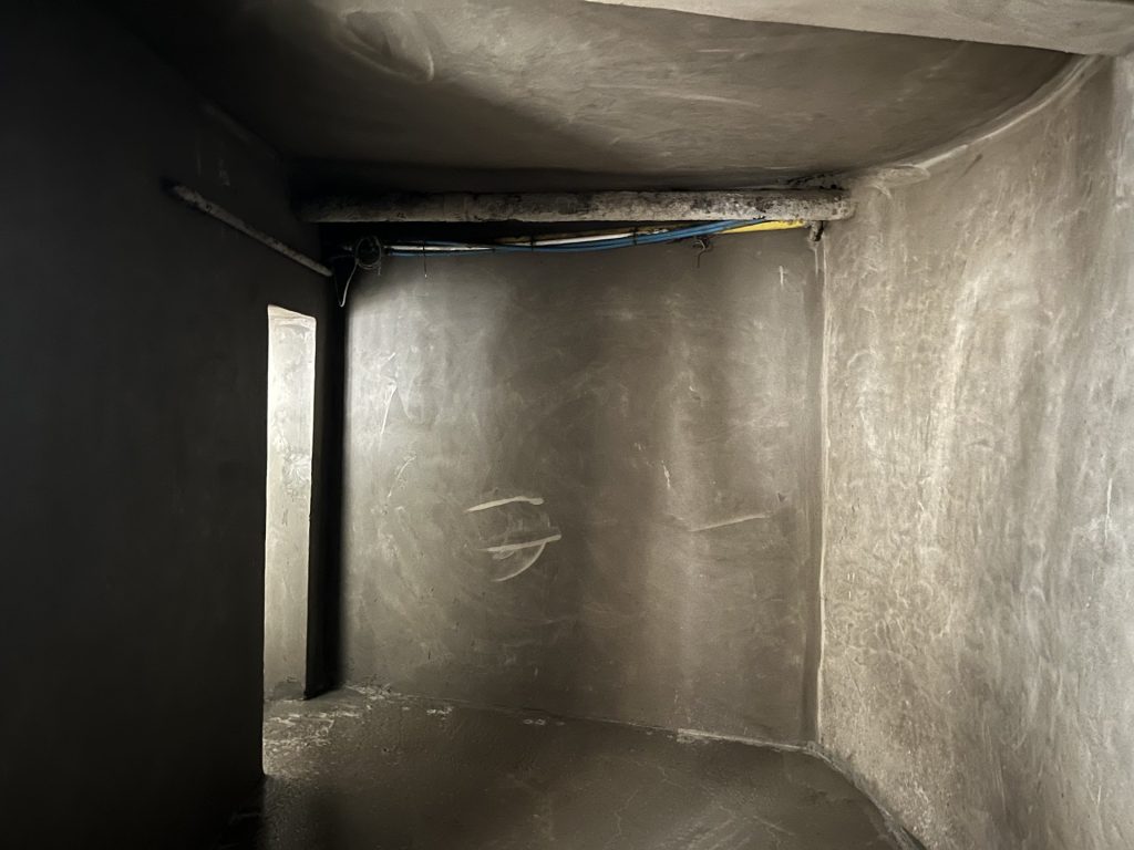 Grey wall, soffit and floor surfaces in the storage room, with a doorway on the left. Grey wall, soffit and floor surfaces in the storage room, with a doorway on the left.